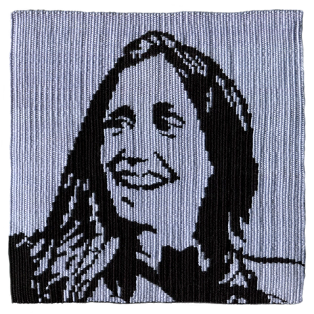 Imagen de un tapiz tejido a telar que reproduce el retrato de Gladys Marín, dirigenta comunista y activista contra la dictadura. La imagen está tejida en negro sobre un fondo celeste.